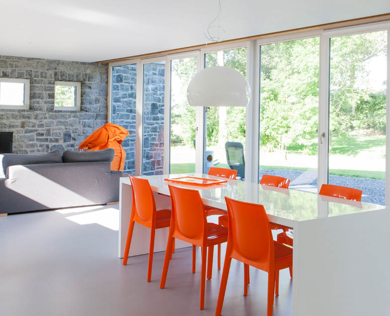 Menuiserie-Riche-tombant-coulissant-multiples-vue-intérieure-blanc-chaises-oranges-nouvelle-construction.jpg