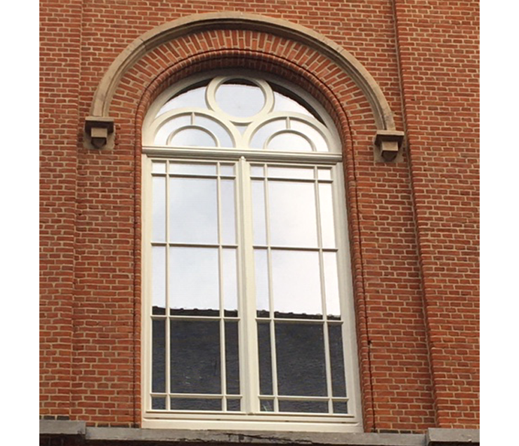 Un bâtiment en brique avec une grande fenêtre cintrée photo